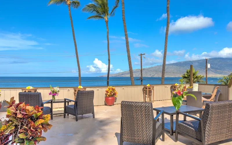 Ocean-view terrace with palm trees at Kohea Kai Hotel Maui in north Kīhei