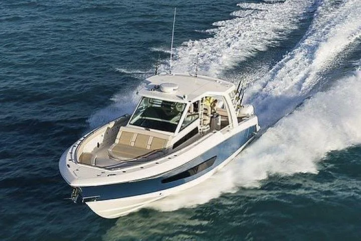 Aerial view of a white center-console powerboat speeding across dark blue water