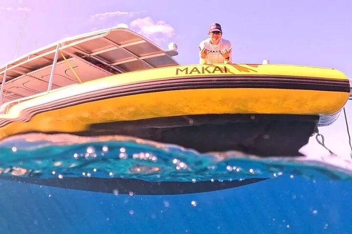 Split-level view of a yellow Makai boat hull with a crew member on deck above